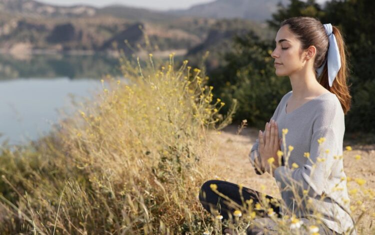 una giovane donna medita immersa nella natura